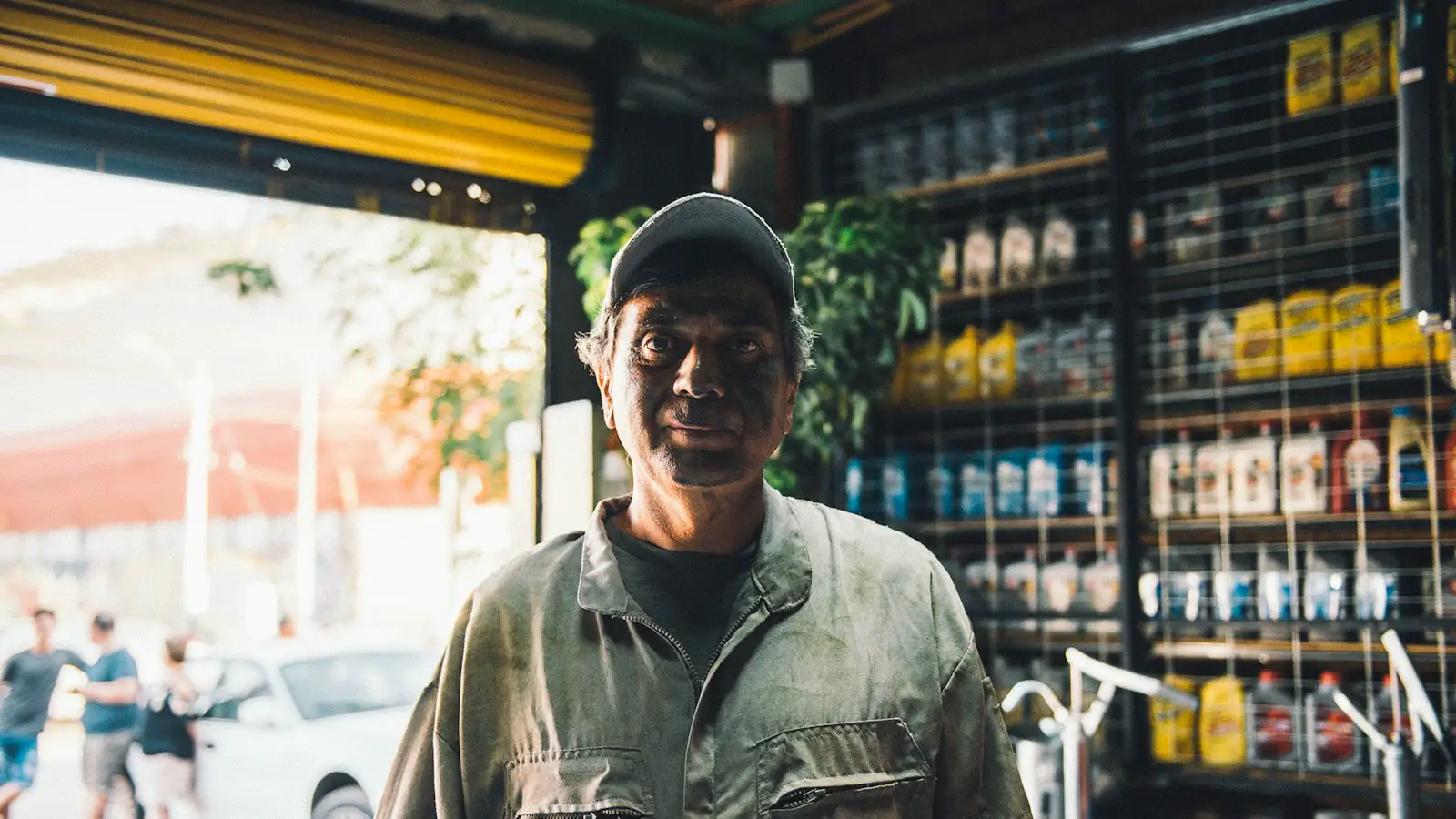A shop owner standing in front of his rolling door