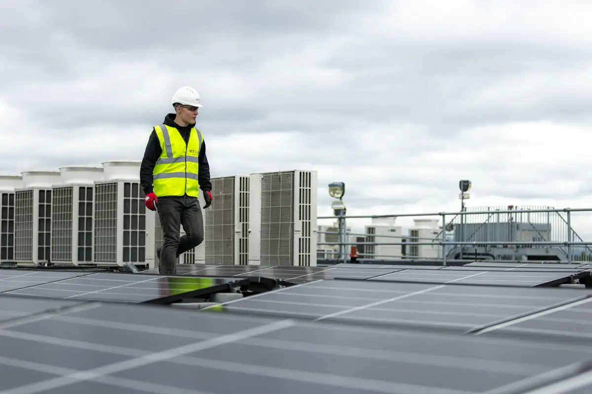 A technician walking a rooftop full of HVAC units
