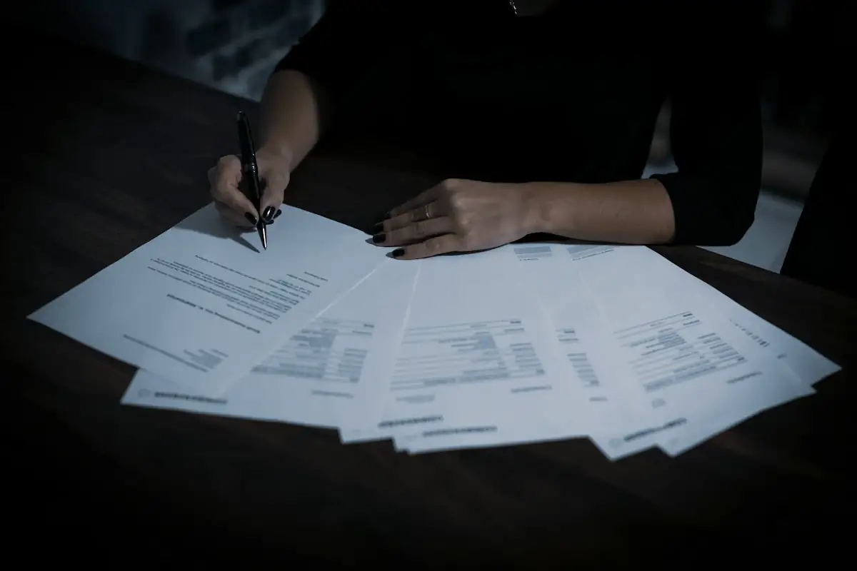 A person at a table covered with loose paperwork