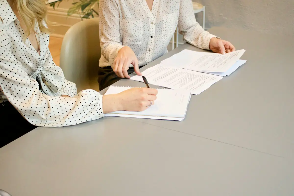 Two people signing paperwork together