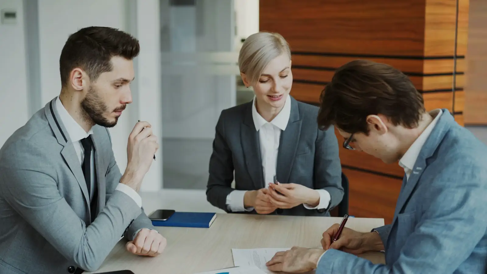 A client signing documents with a professional across the table
